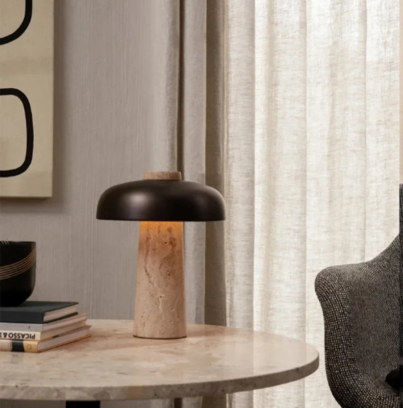 Lampe nordique allumée sur une table ronde devant des rideaux clairs