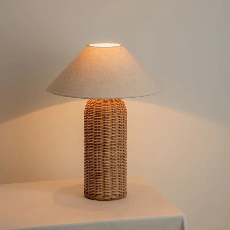 Lampe Wabi-Sabi allumée avec pied cylindrique tressé et abat-jour évasé