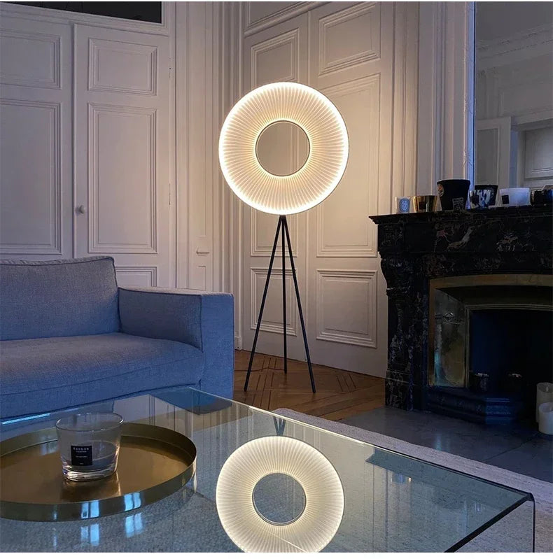 Lampadaire rond allumé sur trépied noir dans un salon avec cheminée