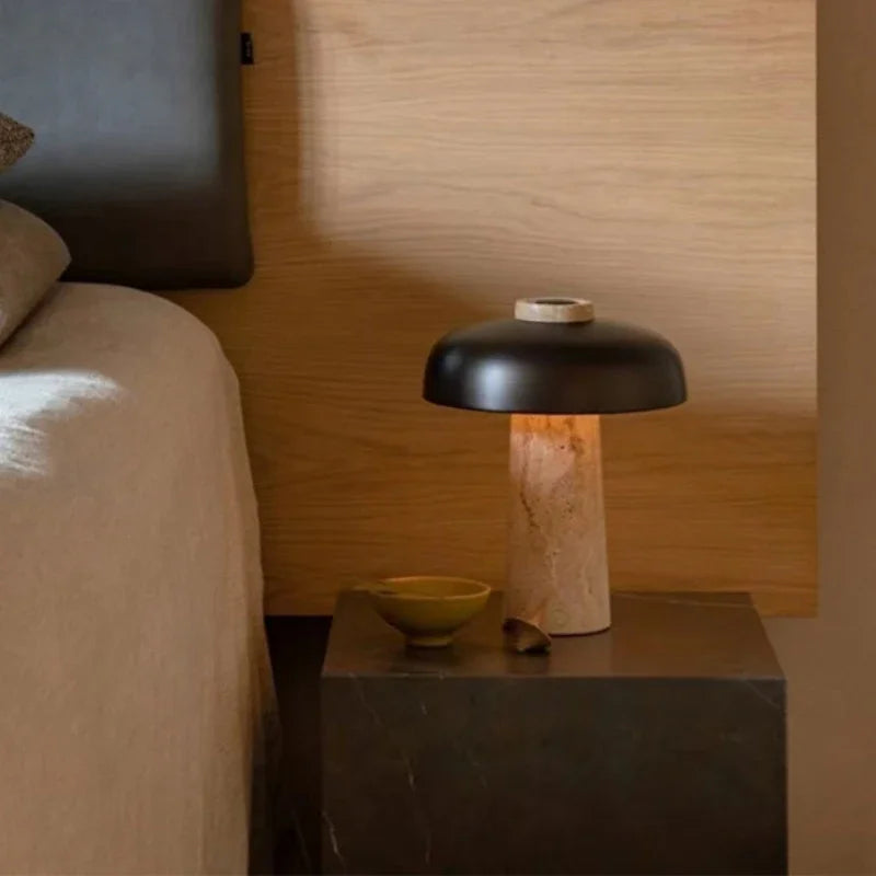 Lampe nordique en pierre avec abat-jour noir sur une table de chevet près du lit