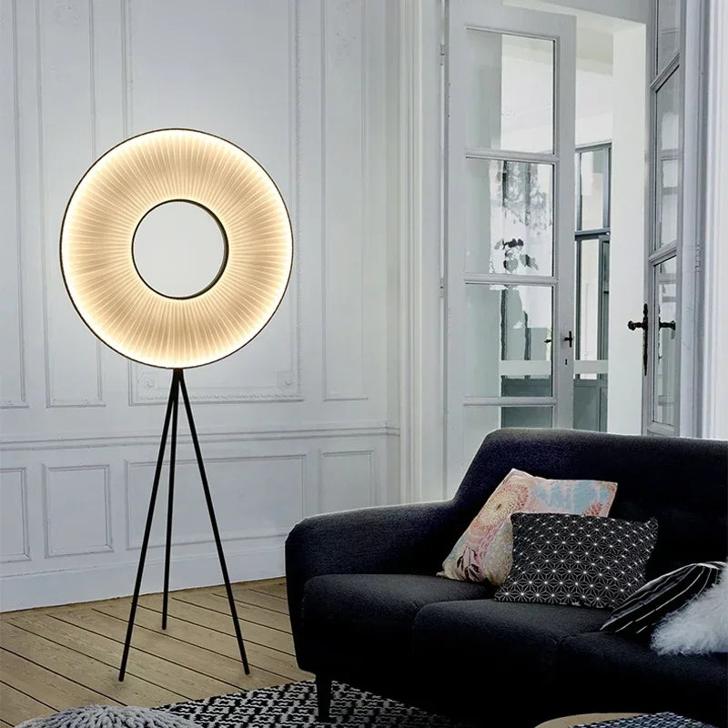 Lampadaire rond plissé allumé près d’un canapé sombre